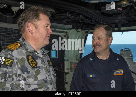 CORAL SEA (Luglio 14, 2017) Capt. Larry McCullen (a destra), comandante della Amphibious Assault nave USS Bonhomme Richard (LHD 6), parla con Royal Australian Navy Capt. Guy Holthouse, Mare Combat Commander per il talismano di Saber 2017 combinata Forza anfibia, sulla nave's Bridge durante il talismano di Saber 17. Bonhomme Richard, parte di un combinato di U.S.-Australia e Nuova Zelanda expeditionary strike gruppo, sta subendo una serie di scenari che aumenterà naval abilità nel funzionamento contro blu-acqua minacce del contraddittorio e nella sua missione primaria di lanciare le forze di marino a terra in Foto Stock