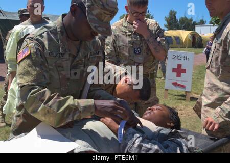 US Army Spc. Mosè Kiplagat, un paziente impiegata amministrativa con il 212th Combat Support Hospital, 30 Brigata medica, si applica un numero banda ad un paziente che arrivano a una massa casualty esercizio a Mihail Kogalniceanu Air Base, Romania il 16 luglio 2017. L'esercizio era una parte di Saber Custode, un comando europeo, US Army Europa-led esercizio tra gli Stati Uniti e i suoi alleati e partner che abbraccia diversi paesi in Europa Orientale ed è progettato per favorire la disponibilità e di rafforzare le relazioni nella regione. Foto Stock