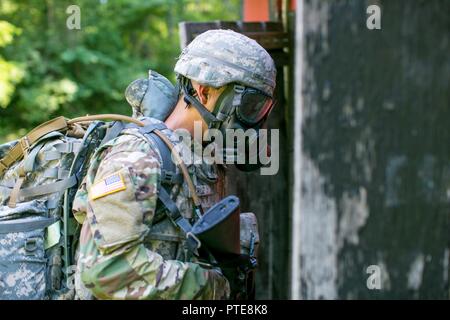 Stati Uniti Army Sgt. Luis Cruz, assegnato alla 688th rapida apertura porta elemento, entra in una zona contaminata indossando una maschera a gas durante un chimico, biologico, radiologico e nucleare scenario come parte dell'esercito 2017 Materiel del comando guerriero migliore concorrenza Luglio 17, 2017, a Camp Atterbury, Indiana. Durante i tre giorni di gara, questi guerrieri elite sono prova sulla base e avanzate attività di guerriero e trapani. Foto Stock