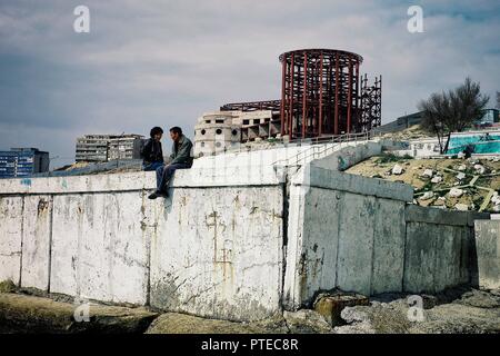 Aktau / Kazakistan - Apr 28 2011: coppia giovane chiacchierando e parlando sul lungomare del deserto ex città sovietica Foto Stock