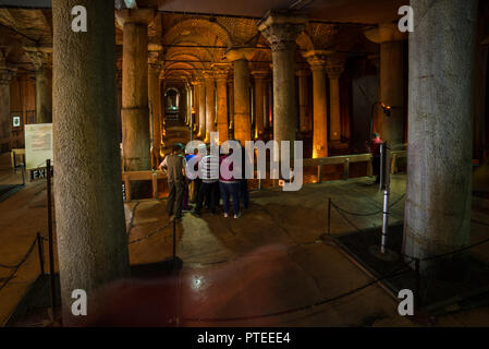 Un gruppo di turisti in piedi nella antica Basilica Romana o cisterna Yerebatan Sarnıcı con colonne di marmo intorno a loro, Istanbul, Turchia Foto Stock