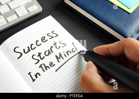 L uomo è iscritto il successo inizia nella mente in una nota. Foto Stock