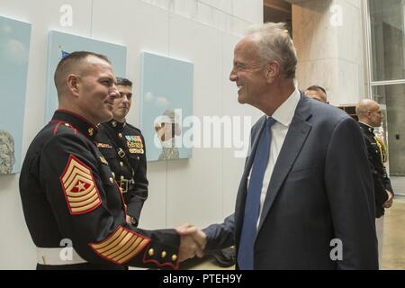 Il Sen. Gerald W. Moran (KS) parla con gli Stati Uniti Marine Corps Sgt. Il Mag. Matthew Hackett, sergente maggiore, caserma marini Washington, durante una parata di tramonto accoglienza presso le donne in servizio militare per l'America Memorial, Arlington, Virginia, luglio 11, 2017. Sunset parate sono tenuti come mezzo di onorare gli alti funzionari, illustri cittadini e sostenitori del Marine Corps. Foto Stock