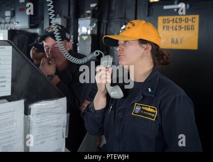 Mare Mediterraneo (15 luglio 2017) Il tenente jg. Valorie Tucciaroni comunica a un'altra nave a bordo guidato-missili cruiser USS Mare delle Filippine (CG 58). Mare delle Filippine, parte del George H.W. Bush Carrier Strike gruppo (GHWBCSG), sta conducendo operazioni navali negli Stati Uniti Sesta flotta area di operazioni a sostegno degli Stati Uniti per gli interessi di sicurezza nazionali in Europa e in Africa. Foto Stock