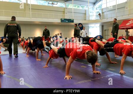 Stati Uniti Marines con stazione di reclutamento di Baltimora, Marine Corps il reclutamento di comando, di motivare i giovani lottatori durante il Corpo della Marina degli Stati Uniti lo sport La Leadership Academy warm-up session a York College di York, Pa., luglio 18, 2017. La USMC Sport La Leadership Academy atleta combina lo sviluppo con la costruzione di caratteri con Marines e pullman. Foto Stock