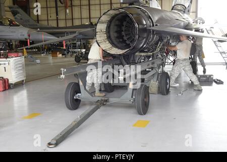 114Manutenzione aeromobili squadrone negozio motore aviatori staccare il motore di un F-16 durante il de-fase di rivestimento di pannelli di una fase di ispezione di manutenzione a Joe Foss Campo, Luglio 8, 2017. Ogni aeromobile è richiesto di passare attraverso una fase di controllo ogni 400 ore di volo per assicurarsi che tutti i sistemi funzionino entro Air Force regolamenti. Foto Stock