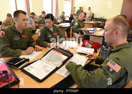 Il cap. Concessione Lewis (sinistra) Il Mag. Shannon Wrage, sia dall'182nd Airlift Wing, Illinois Air National Guard e 1Lt. Justin Newton dal centoventesimo Airlift Wing, Montana Air National Guard, le note di revisione durante un volo briefing al Papa Air Base, Ungheria, prima di condurre una caduta di personale a Bezmer Air Base, Bulgaria, 18 luglio 2017 durante l'esercizio Risposta rapida 17. Risposta rapida è legata a esercitare Saber custode di un U.S. Esercito Europa-led, esercizio di multinazionali che si estende attraverso la Bulgaria, l Ungheria e la Romania con più di 25.000 membri del servizio da 22 alleati e partner delle nazioni. Foto Stock