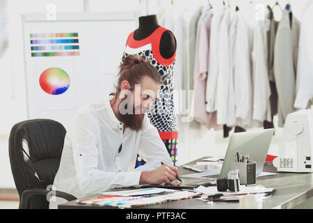 Successo designer lavorando su nuovi schizzi di vestiti Foto Stock