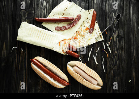 Preparazione di hot dog con salsiccia e salsicce Foto Stock