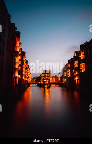 Amburgo, Germania. Vista di Wandrahmsfleet durante il tramonto con edifici illuminati. Landmark Warehouse District - Speicherstadt di HafenCity trimestre. La maggior parte ha visitato touristic famosa Place Foto Stock