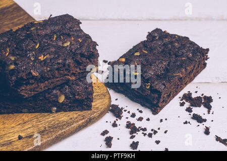 Zucchine vegana flourless paleo brownies e zucca brownies (cheto, low carb e privo di glutine) su uno sfondo di legno. Close up Foto Stock