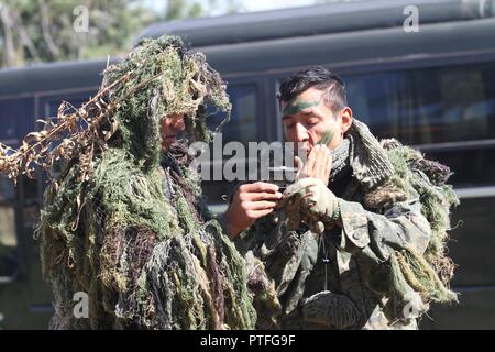 Un concorrente messicano aiuta il suo compagno di squadra a nascondere il suo viso prima levetta-e-shoot caso Luglio 20, 2017 durante Fuerzas Comando in Ñu Guazú, Paraguay. Fuerzas Comando è sulla promozione di partenariati e di portare le Americhe insieme. Foto Stock