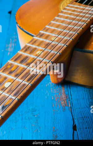 Una vista della vecchia chitarra classica su sfondo blu, primo piano Foto Stock