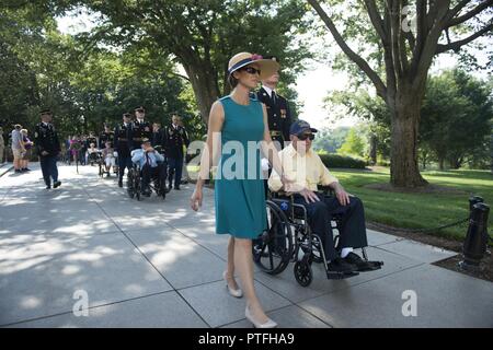 La sig.ra Katharine Kelley, sovrintendente, il Cimitero Nazionale di Arlington passeggiate con la USS Arizona superstiti presso il Cimitero Nazionale di Arlington, Arlington, Virginia, luglio 21, 2017. I sopravvissuti hanno partecipato in precedenza in una delle Forze Armate ghirlanda di cerimonia di posa presso la tomba in riconoscimento dell attacco alla Naval Corazzata USS Arizona e il 1.777 marinai che sono stati uccisi durante l'attacco di Pearl Harbor il 7 dicembre 1941. Foto Stock