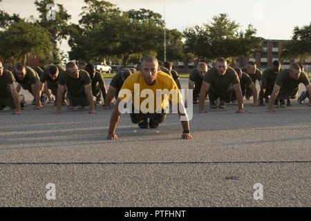 Stati Uniti Marine Corps Gunnery Sgt. Luis Turner, senior drill instructor, plotone 2049, hotel azienda, 2a reclutare battaglione di formazione, esegue pushups prima di una esecuzione motivazionale in parata Peatross coperta di Marine Corps reclutare Depot, Parris Island, S.C., 13 luglio 2017. Motivazionali Run è effettuata il giorno della festa della famiglia prima della nuova Marines vedere le loro famiglie ancora dopo tredici settimane di formazione. Foto Stock