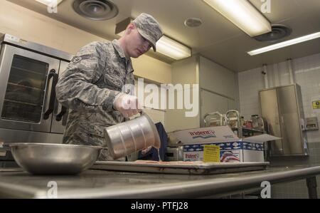 Stati Uniti Air Force Senior Airman Jason Parchi, un trentacinquesimo forza squadrone di supporto per il food service technician, prepara i filetti di salmone nel Falcon alimentatore a Misawa combatté Air Base, Giappone, luglio 18, 2017. L'edificio è stato originariamente progettato per essere un volo in cucina, ma è stato ridefinito in una sala da pranzo secondario facility in seguito. Foto Stock