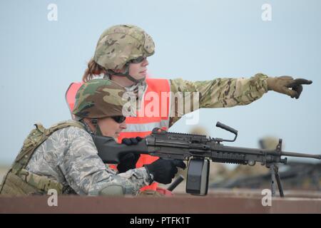 Stati Uniti Air Force Senior Airman Angela Lage, della 219th delle forze di sicurezza Squadron, punti a bersagli come lei fornisce assistenza al Col. Bryan Delage, del 119° Gruppo medico, durante la sua arma familiarizzazione sparando il M249 mitragliatrice presso il poligono di tiro a Camp Gilbert C. Grafton, North Dakota, luglio 19, 2017. Delage è un medico in 119Medical Group, e sono entrambi membri del North Dakota Air National Guard. Foto Stock
