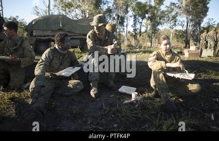 QUEENSLAND, Australia - Lance Cpl. Emmanuel Gacel (sinistra), fuciliere, e Lance Cpl. Gavin McDougle, il trasporto del motore meccanico, sia con società L, 3° Battaglione, 4° Reggimento Marini, 1° Divisione Marine, Marine forza rotazionale di Darwin, di avere un pasto con Australian Defence Force Pvt. Madeline Dunjey, operatore del veicolo con 1° Battaglione, il Royal Australian Regiment, durante l'esercizio talismano Saber 17 Field Training esercizio - est, 19 luglio 2017. L'esercizio una maggiore interoperabilità tra U.S. forze armate e difesa australiana di forze per imparare gli uni dagli altri di tattiche. Talismano Sabe Foto Stock