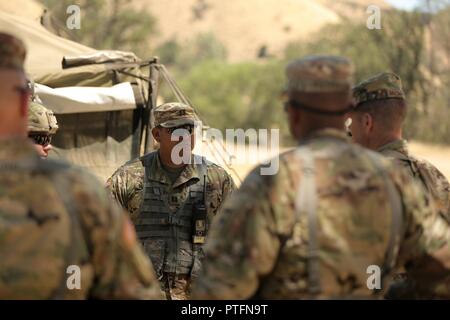 Stati Uniti Esercito Capt. Gustavo Madrigal, centro con Cavalleria 4 multi-funzionale la brigata di formazione, Fort Knox, Kentucky, e l'osservatore pullman/istruttore capo del team di "Killer Team", SLIP Il Mag. Gen. Todd McCaffrey, comandante generale dell esercito prima divisione Ovest, sull'unità di sviluppo durante la lotta contro la formazione di supporto esercizio 91-17-03, 18 luglio 2017, a Fort Hunter Liggett, California Madrigal è un laureato dell'U.S. Accademia Militare di West Point, New York, dove ha studiato ingegneria aerospaziale e di storia. Poiché la sua laurea, ha servito nell'esercito operante nel campo della progettazione. Foto Stock