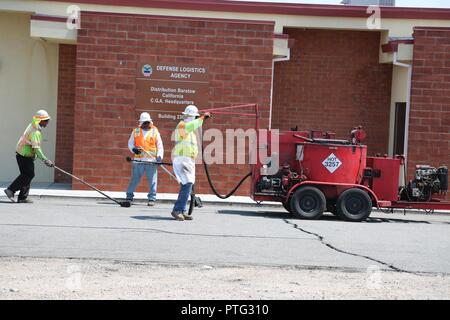 Strada contratta equipaggio lavoratori pulire e riempire crepe nella pavimentazione in tutto Marine Corps base logistica Barstow come parte di un lungo mesi progetto di riaffiorare le strade e parcheggi sulla base, 11 luglio. Foto Stock