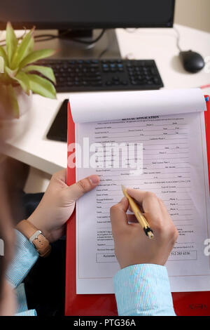 L'uomo tenendo pen, appunti e foglio in mano. Foto Stock