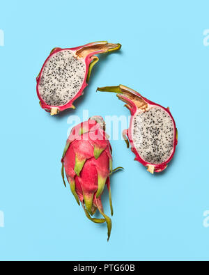 Due metà e tutta una frutta tropicali pitahaya presentata su uno sfondo blu con copia spazio. Layout di cibo. Lay piatto Foto Stock
