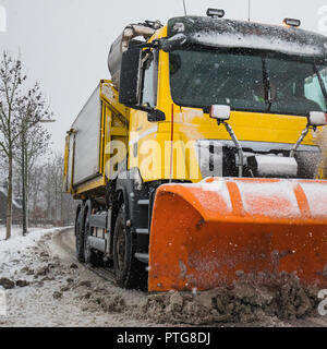 Spartineve rimuove la neve fuori strada ghiacciata in inverno Foto Stock