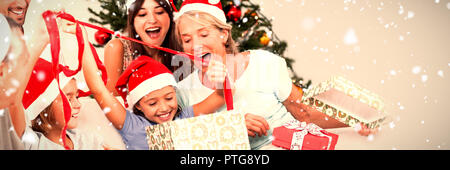 Immagine composita della famiglia felice a Natale regali di apertura insieme Foto Stock