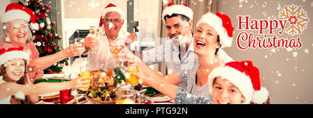 Immagine composita della famiglia in cappelli di Babbo Natale tostatura di bicchieri di vino al tavolo da pranzo Foto Stock