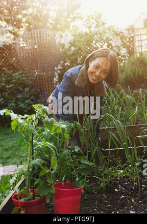 Ritratto sorridente senior attiva donna giardinaggio Foto Stock