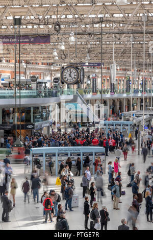 Sfocata passeggeri in attesa per i treni a Waterloo Station di Londra. Tutti girati dal balcone sopra l'atrio. Foto Stock