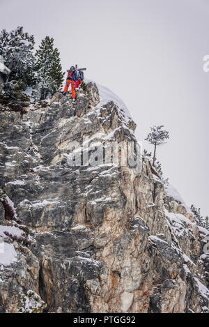 Fuori pista gli sciatori sono praticare arrampicate su roccia. Foto Stock