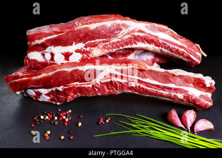 I mangimi e gli alimenti. Carne di maiale cruda. Carni suine fresche tagliate la pancetta e la pancetta e barbecue grigliate Foto Stock