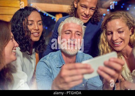 Gli amici utilizzando smart phone Foto Stock