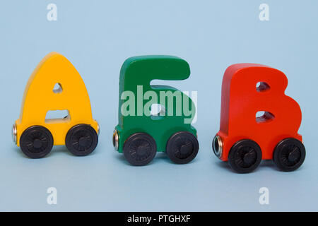 Russo lettere di legno treno alfabeto con locomotore. Colori luminosi di colore rosso giallo verde e blu su uno sfondo bianco. Educazione della prima infanzia, le Foto Stock