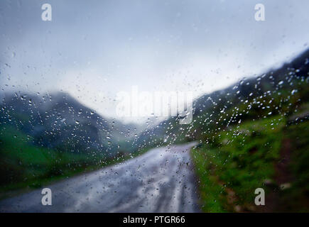 Viaggi e strada di montagna sul giorno di pioggia. Finestra auto paesaggio tempesta Foto Stock