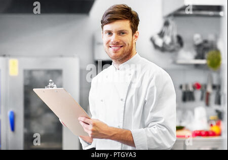 Chef con appunti facendo un inventario presso ristorante Foto Stock