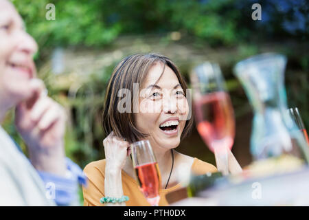 Ridendo senior donna godendo party in giardino Foto Stock