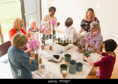 Active seniors godendo di decorazione floreale di classe Foto Stock