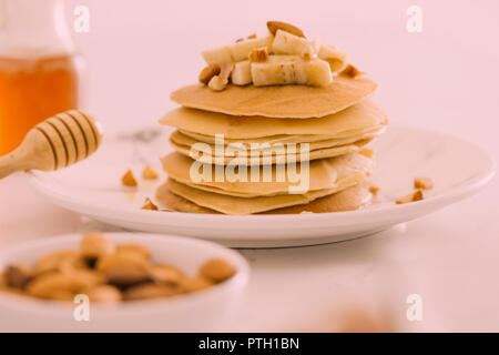 Banana anacardi pancake con banane e salsa al caramello. alla tonificazione. messa a fuoco selettiva Foto Stock