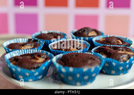 Close up artigianale di tortini di cioccolato con pezzi di pera in piastra su uno sfondo colorato con il fuoco selettivo. Foto Stock