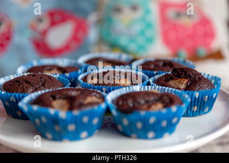 Close up artigianale di tortini di cioccolato con pezzi di pera in piastra su uno sfondo colorato con il fuoco selettivo. Foto Stock