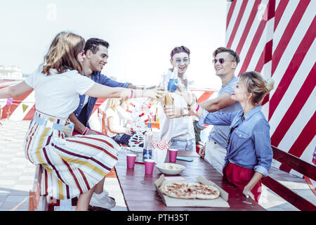 Gioiosa studenti aventi la birra party sul tetto Foto Stock