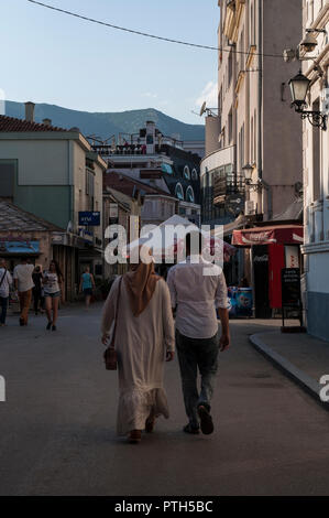 La Bosnia ed Erzegovina, Europa: una donna musulmana velata camminando con il suo marito per le strade della città di Mostar Foto Stock