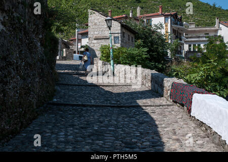La Bosnia ed Erzegovina: una donna il trasporto delle borse della spesa camminando sui ciottoli nelle viuzze della vecchia città di Mostar in un giorno di estate Foto Stock