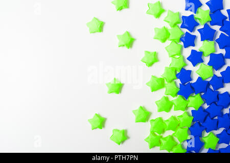 Due stelle colorate di carta su uno sfondo bianco con spazio di copia Foto Stock