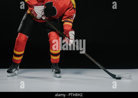 Tagliate del tiro sportivo con la mazza da hockey la riproduzione di hockey su ghiaccio su nero Foto Stock