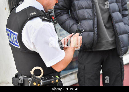 Il sergente Andy Ford da Merseyside polizia completa un arresto e modulo di ricerca durante un arresto e funzionamento della ricerca in Bootle area di Liverpool Foto Stock