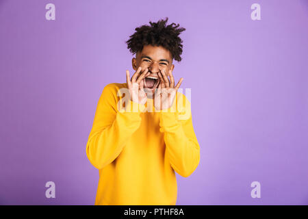 Ritratto di un allegro giovani afro american uomo vestito in felpa gridando isolato Foto Stock