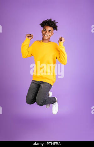 Ritratto di un allegro giovani afro american uomo vestito in felpa jumping isolato Foto Stock
